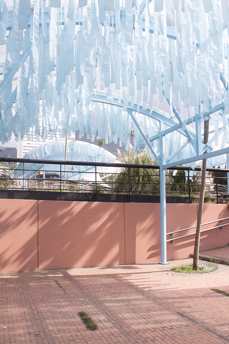 blue fabric fragments dance with the wind on modular cultural pavilion in colombia